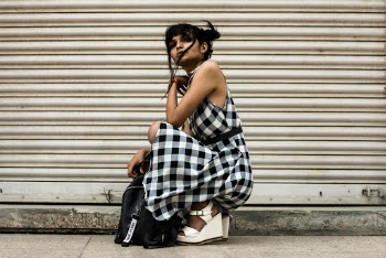 Woman Sitting in Front of White Shutter Door