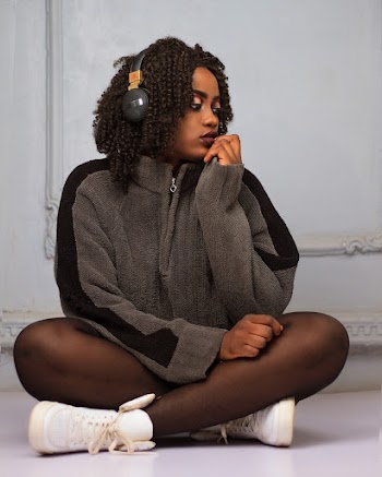 Woman Sitting in Front of White Wall