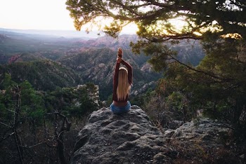 woman sitting in gray rock watching nature