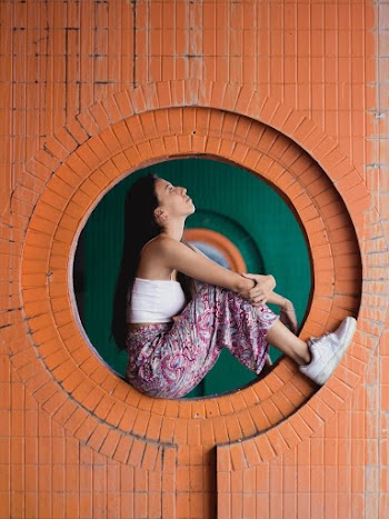Woman Sitting in Wall Hole