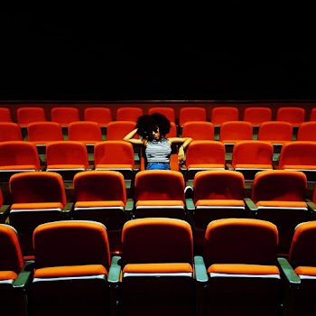 Woman Sitting Inside A Theater