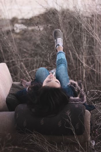 woman sitting lying on sofa chair