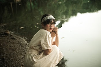 Woman Sitting Near Body of Water