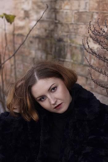 Woman Sitting Near Brown Wall