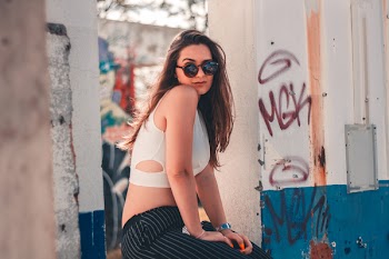 Woman Sitting Near Graffiti-printed Walls