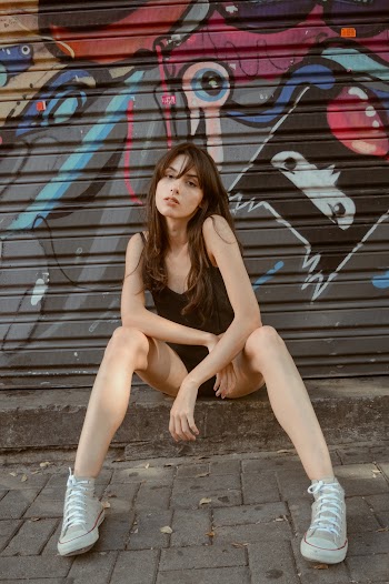 Woman Sitting Near Graffitti