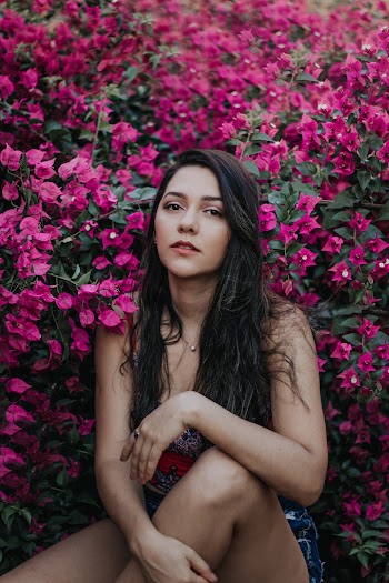 Woman Sitting Near Pink Flowers