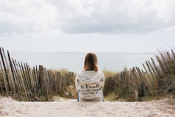 Woman Sitting Near Plants and Fence