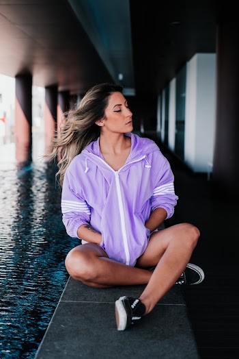 Woman Sitting Near River Under Bridge