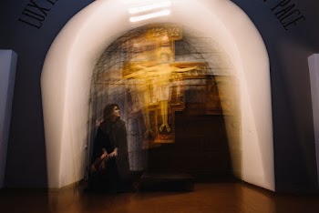 Woman Sitting Near Statue of Jesus Christ