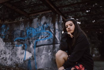 Woman Sitting Near Wall