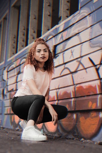 Woman Sitting Near Wall