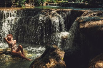Woman Sitting Near Waterfalls