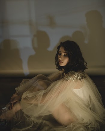 Woman Sitting Near White Wall