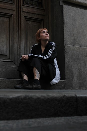 Woman Sitting Near Wooden Door