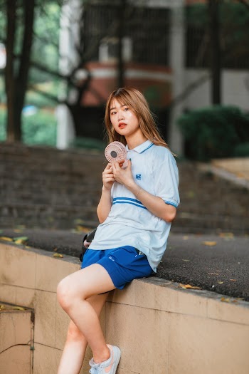 Woman Sitting on a Concrete Wall