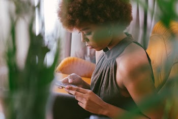 Woman Sitting On A Couch While Using Her Phone