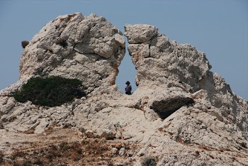 Woman Sitting On A Hole In The Middle Of A Huge Rock Formation