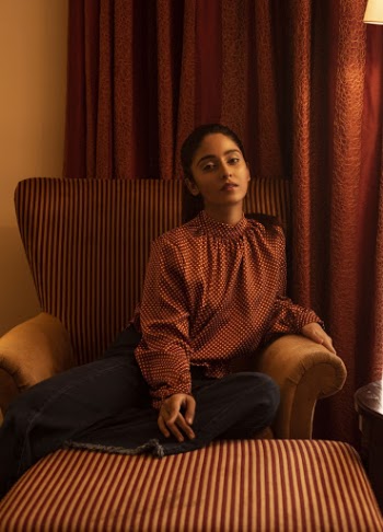 Woman Sitting on a Sofa Chair in a Room