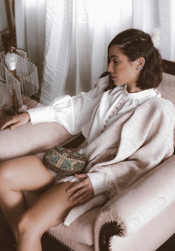 Woman Sitting on Armchair Beside White Curtains
