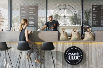 Woman Sitting On Bar Chair Near Barista