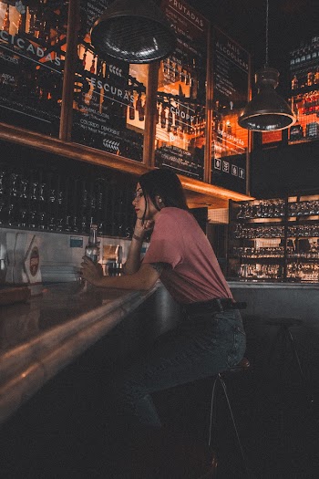 Woman Sitting on Bar Stool