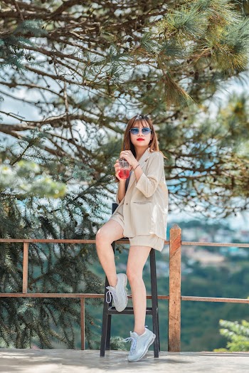 Woman Sitting On Bar Stool Under Green Leafed Tree