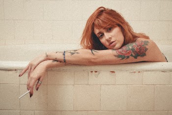 Woman Sitting on Bathtub While Holding Cigarette Stick