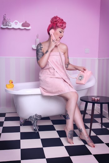 Woman Sitting on Bathtub While Holding Rotary Phone