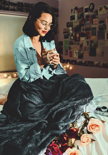 Woman Sitting on Bed Holding a Cup