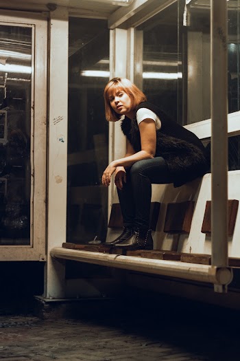 Woman Sitting on Bench in Room