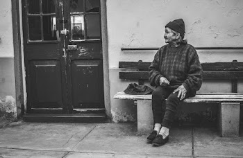 Woman Sitting on Bench Near Closed Door