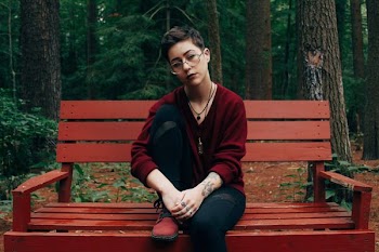 woman sitting on bench near forest