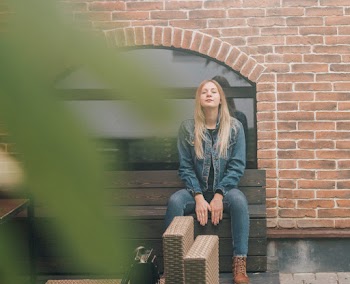 Woman Sitting on Bench Near Wall