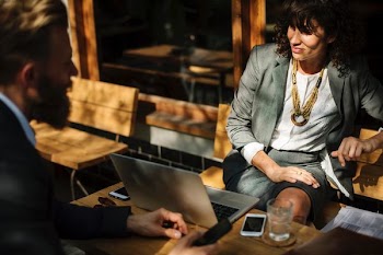 woman sitting on bench while facing on laptop