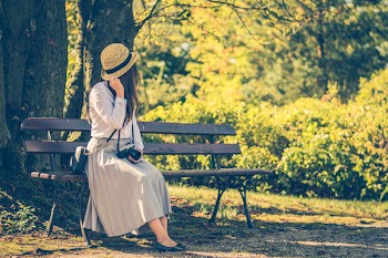 Woman Sitting on Bench While Looking on Left Side