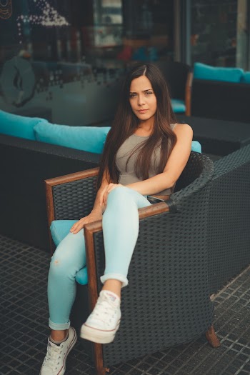 Woman Sitting on Black Wicker Tub Chair