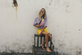 Woman Sitting on Black Wooden Armchair Beside White Painted Wall Posing for Photo