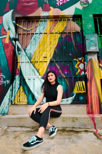 Woman Sitting on Blue and Yellow Graffiti