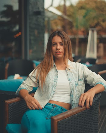 Woman Sitting on Blue Wooden Armchair