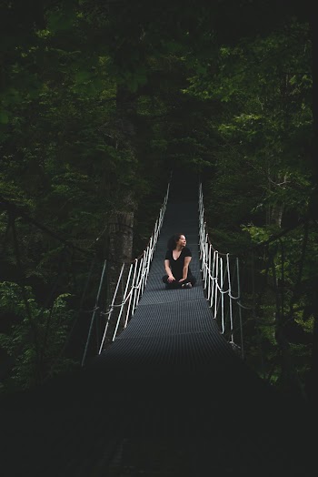 Woman Sitting On Bridge