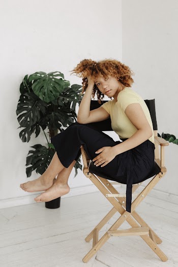 Woman Sitting on Brown and Black Director's Chair