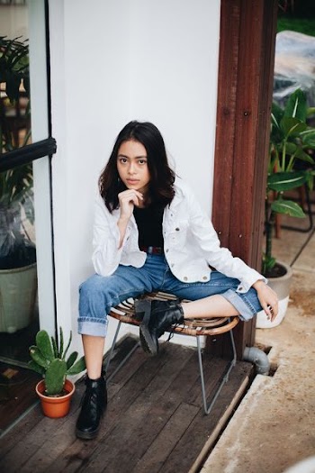 woman sitting on brown chair near green plants