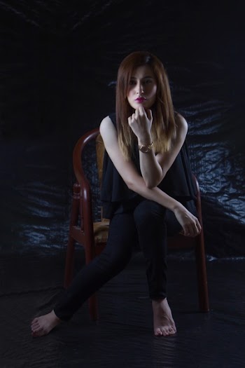 Woman Sitting on Brown Chair With Black Background