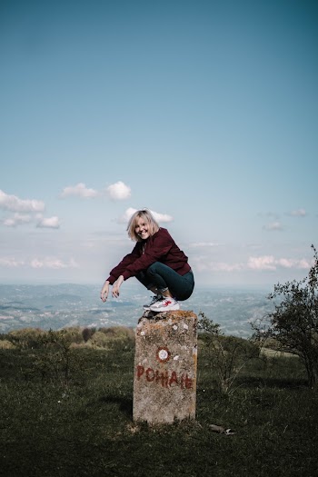 Woman Sitting on Brown Concrete Stand