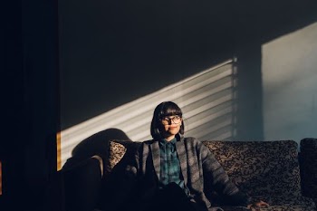 woman sitting on brown floral sofa