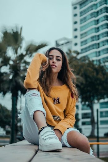 woman sitting on brown surface while being photographed