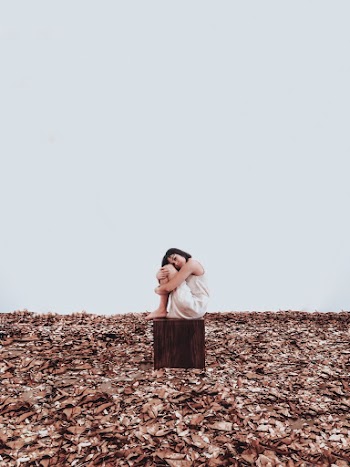Woman Sitting On Brown Wooden Box 