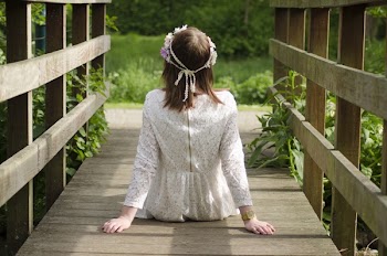 Woman Sitting on Brown Wooden Bridge