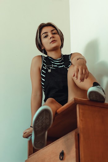 Woman Sitting on Brown Wooden Dresser